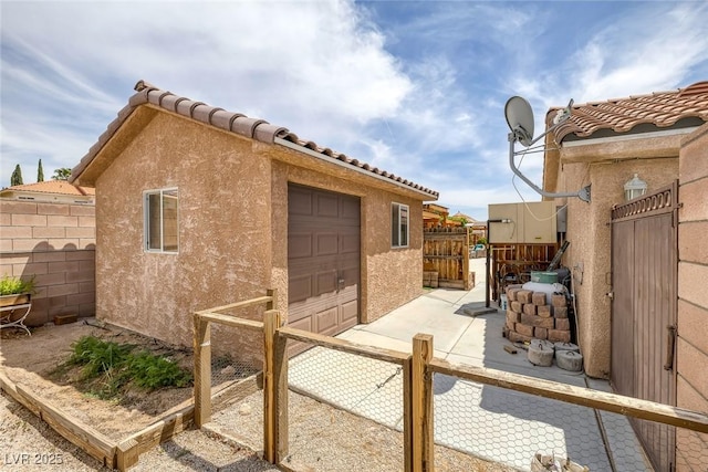 9015 S Tenaya Way, Las Vegas, NV 89113 - view of side of home with stucco siding, a garage, and an outbuilding