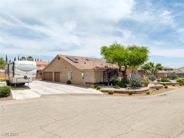 9015 S Tenaya Way, Las Vegas, NV 89113 - view of front of home featuring solar panels, concrete driveway, stucco siding, and an attached garage