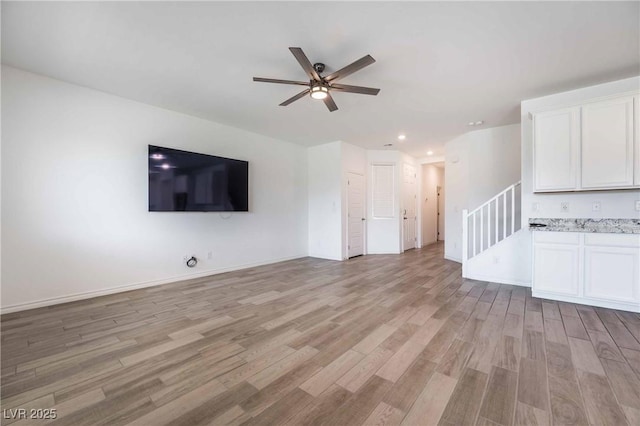 7124 Sayonara Vista St, North Las Vegas, NV 89084 - unfurnished living room featuring ceiling fan, light wood-style flooring, recessed lighting, and stairs