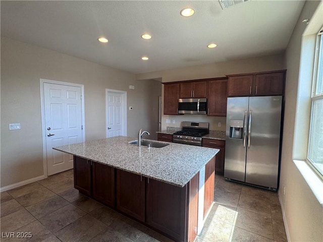 2653 Crystal Blue St, Laughlin, NV 89029 - kitchen featuring appliances with stainless steel finishes, recessed lighting, a center island with sink, light stone counters, and dark brown cabinetry