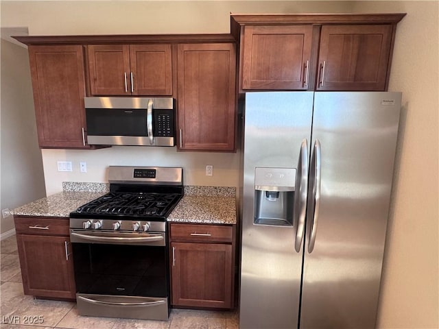 2653 Crystal Blue St, Laughlin, NV 89029 - kitchen with stainless steel appliances, light stone counters, and light tile patterned floors