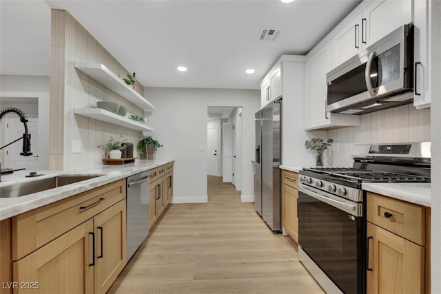 7701 Sea Cliff Way, Las Vegas, NV 89128 - kitchen with stainless steel appliances, light wood-style flooring, recessed lighting, tasteful backsplash, and open shelves