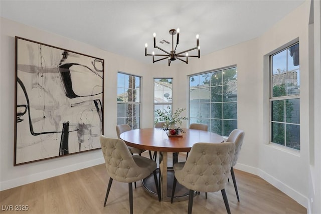 7701 Sea Cliff Way, Las Vegas, NV 89128 - dining area with a chandelier, wood finished floors, and healthy amount of natural light