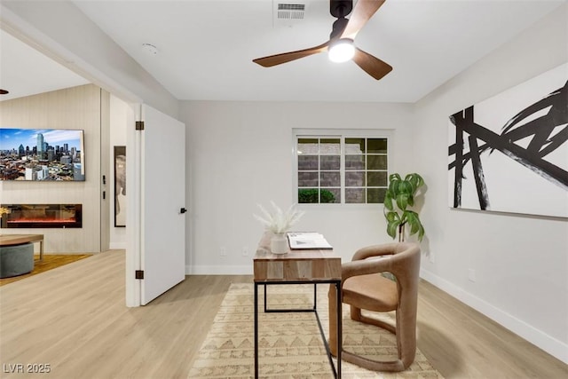 7701 Sea Cliff Way, Las Vegas, NV 89128 - office space featuring ceiling fan, light wood-style flooring, and a glass covered fireplace