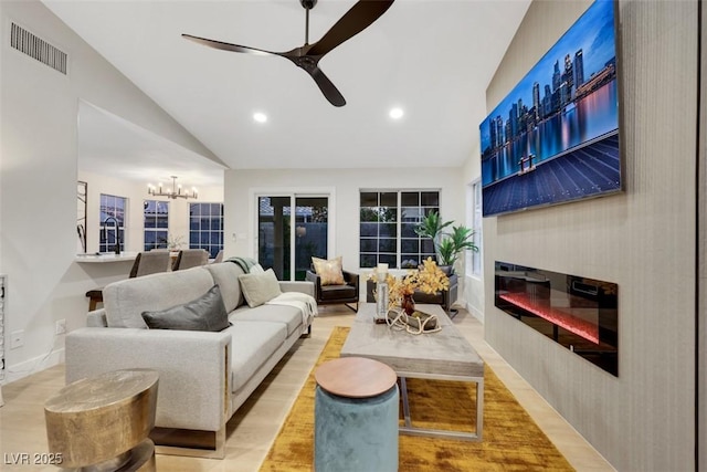 7701 Sea Cliff Way, Las Vegas, NV 89128 - living room featuring ceiling fan, a glass covered fireplace, high vaulted ceiling, a chandelier, and recessed lighting