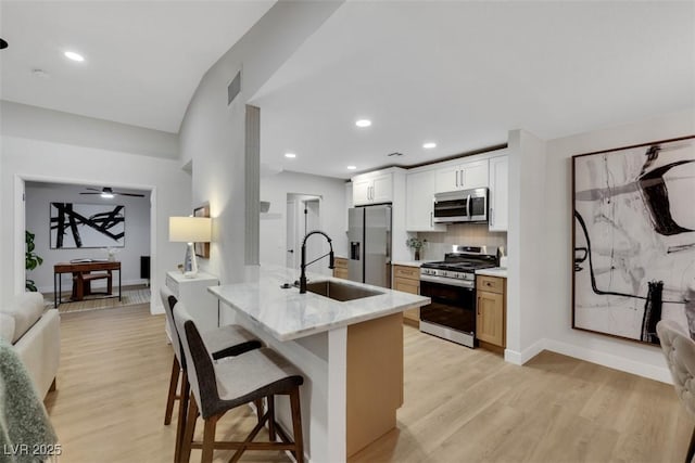 7701 Sea Cliff Way, Las Vegas, NV 89128 - kitchen featuring stainless steel appliances, light wood-type flooring, a breakfast bar, backsplash, and recessed lighting