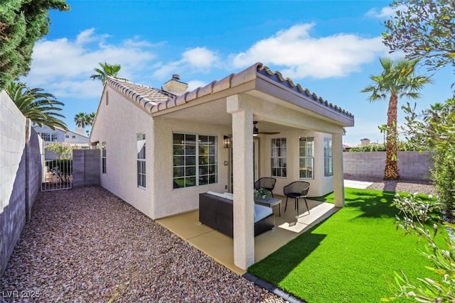 7701 Sea Cliff Way, Las Vegas, NV 89128 - back of property featuring a ceiling fan, stucco siding, a tile roof, a fenced backyard, and a chimney