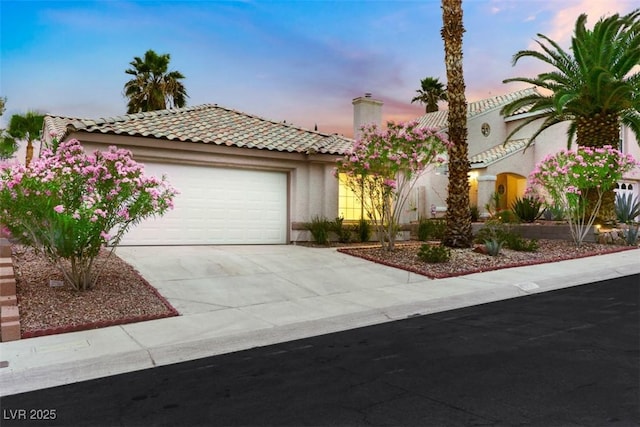 7701 Sea Cliff Way, Las Vegas, NV 89128 - mediterranean / spanish-style home with stucco siding, a garage, driveway, a tiled roof, and a chimney