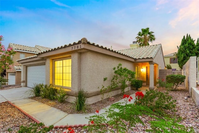 7701 Sea Cliff Way, Las Vegas, NV 89128 - view of front facade featuring stucco siding, a garage, a chimney, a tile roof, and driveway
