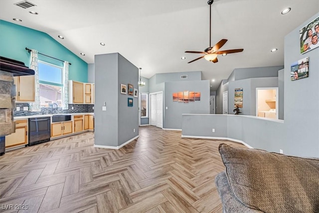 100 Crossfoot Terrace Ct, Henderson, NV 89002 - kitchen with dishwasher, lofted ceiling, light brown cabinetry, open floor plan, and a ceiling fan
