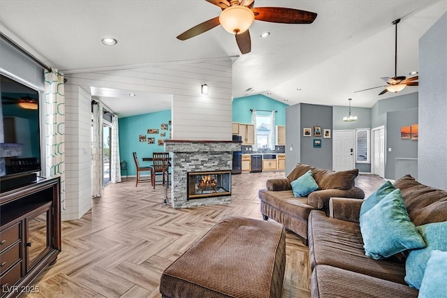 100 Crossfoot Terrace Ct, Henderson, NV 89002 - living area featuring a ceiling fan, vaulted ceiling, a stone fireplace, and wood walls