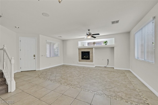 9044 Blue Raven Ave Unit R, Las Vegas, NV 89143 - unfurnished living room with light tile patterned floors, a tile fireplace, ceiling fan, and stairway