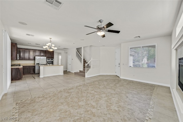 9044 Blue Raven Ave Unit R, Las Vegas, NV 89143 - unfurnished living room featuring a chandelier, light tile patterned floors, stairs, ceiling fan, and a glass covered fireplace