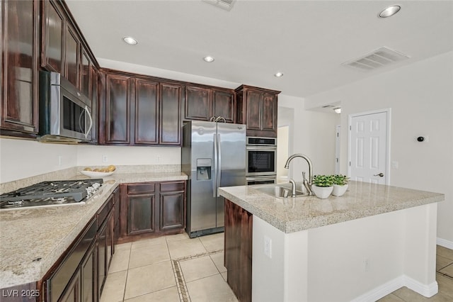 9044 Blue Raven Ave Unit R, Las Vegas, NV 89143 - kitchen featuring stainless steel appliances, light tile patterned floors, recessed lighting, a center island with sink, and dark brown cabinets