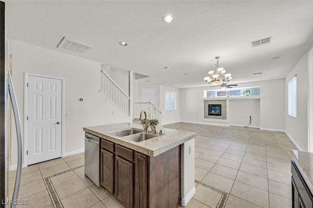 9044 Blue Raven Ave Unit R, Las Vegas, NV 89143 - kitchen with stainless steel dishwasher, light tile patterned flooring, a chandelier, light countertops, and dark brown cabinets