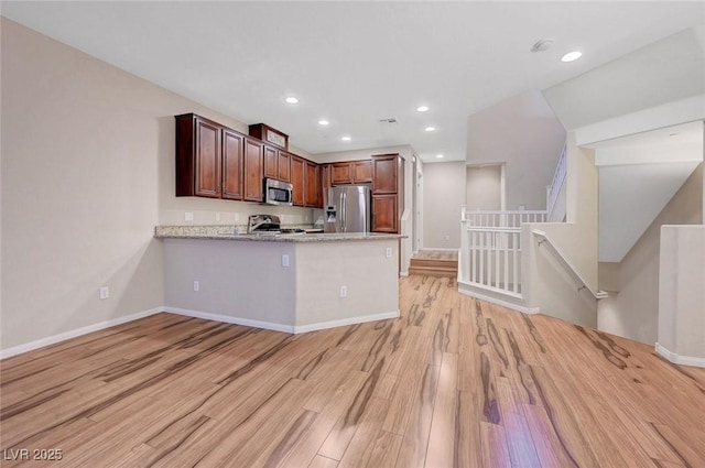 7856 Carysford Ave, Las Vegas, NV 89178 - kitchen with appliances with stainless steel finishes, light wood-style floors, a peninsula, and recessed lighting