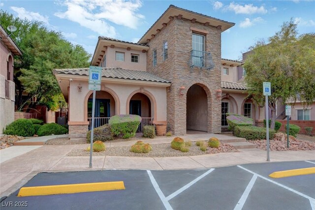 7856 Carysford Ave, Las Vegas, NV 89178 - view of front of home with stucco siding, a tiled roof, a porch, and stone siding