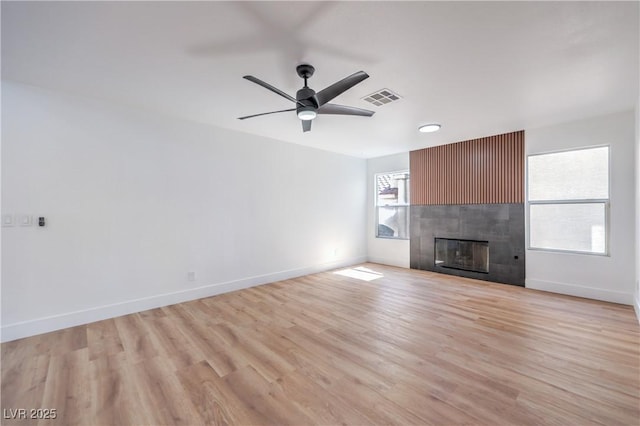 6420 Rosemount Ave, Las Vegas, NV 89156 - unfurnished living room featuring a tiled fireplace, a ceiling fan, and light wood-type flooring