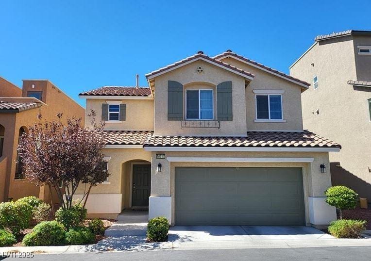 10717 Red Badge Ave, Las Vegas, NV 89166 - mediterranean / spanish home featuring a tiled roof, a garage, stucco siding, and concrete driveway