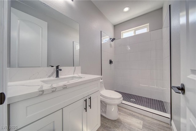 6621 S Parkwood Ct, Pahrump, NV 89061 - bathroom featuring vanity, tiled shower, wood finished floors, and recessed lighting