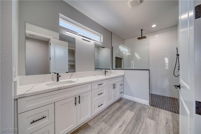 6621 S Parkwood Ct, Pahrump, NV 89061 - bathroom featuring double vanity, walk in shower, and wood finished floors