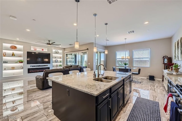 800 Rosewater Dr, Henderson, NV 89011 - kitchen featuring dishwashing machine, an island with sink, a ceiling fan, a chandelier, and pendant lighting