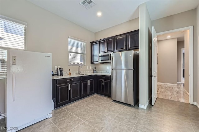 800 Rosewater Dr, Henderson, NV 89011 - kitchen with stainless steel appliances, light tile patterned flooring, light stone countertops, recessed lighting, and dark cabinets