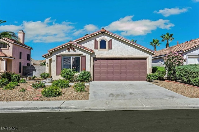 6035 Shadow Oak Dr, North Las Vegas, NV 89031 - mediterranean / spanish house with an attached garage, stucco siding, a tile roof, and concrete driveway