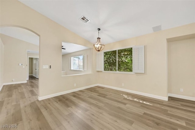 6035 Shadow Oak Dr, North Las Vegas, NV 89031 - unfurnished room with a chandelier, wood finished floors, arched walkways, and lofted ceiling