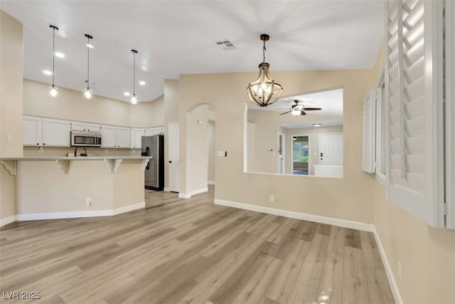 6035 Shadow Oak Dr, North Las Vegas, NV 89031 - unfurnished living room with ceiling fan, light wood finished floors, recessed lighting, a chandelier, and arched walkways