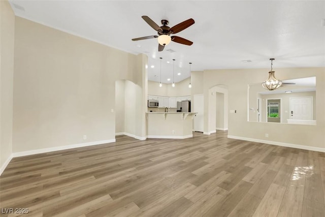 6035 Shadow Oak Dr, North Las Vegas, NV 89031 - unfurnished living room with a ceiling fan, light wood-style flooring, a chandelier, arched walkways, and recessed lighting