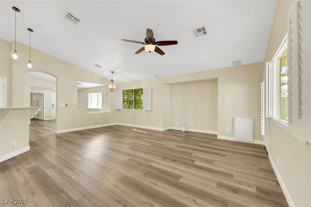 6035 Shadow Oak Dr, North Las Vegas, NV 89031 - unfurnished living room featuring lofted ceiling, ceiling fan, arched walkways, and light wood-style floors