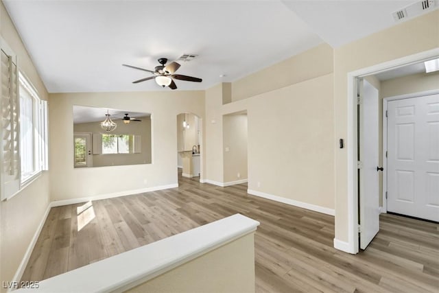 6035 Shadow Oak Dr, North Las Vegas, NV 89031 - unfurnished living room featuring wood finished floors, a ceiling fan, and arched walkways