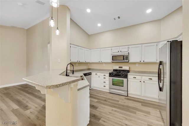 6035 Shadow Oak Dr, North Las Vegas, NV 89031 - kitchen featuring stainless steel appliances, a peninsula, light wood finished floors, white cabinetry, and recessed lighting