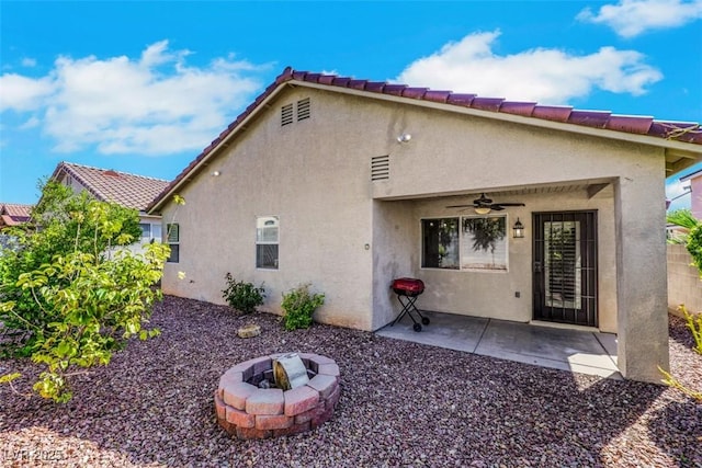 6035 Shadow Oak Dr, North Las Vegas, NV 89031 - rear view of property with a ceiling fan, stucco siding, a patio area, an outdoor fire pit, and a tiled roof