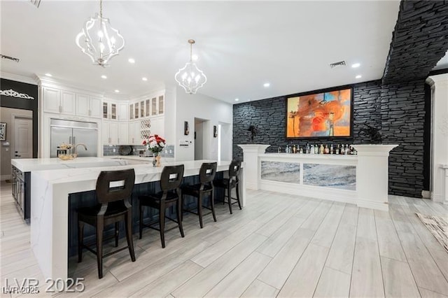 764 Ricota Ct, Henderson, NV 89012 - kitchen with stainless steel built in fridge, a chandelier, a large island, hanging light fixtures, and light wood-style flooring