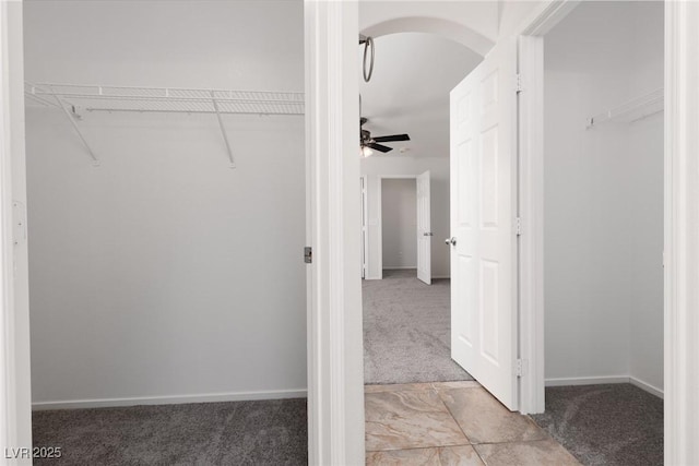 908 Shining Rose Pl, Henderson, NV 89052 - walk in closet with light carpet, arched walkways, and a ceiling fan