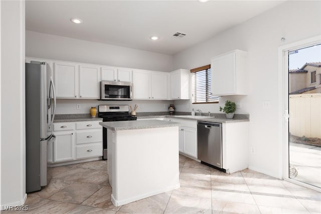 908 Shining Rose Pl, Henderson, NV 89052 - kitchen with stainless steel appliances, white cabinetry, light countertops, a kitchen island, and recessed lighting