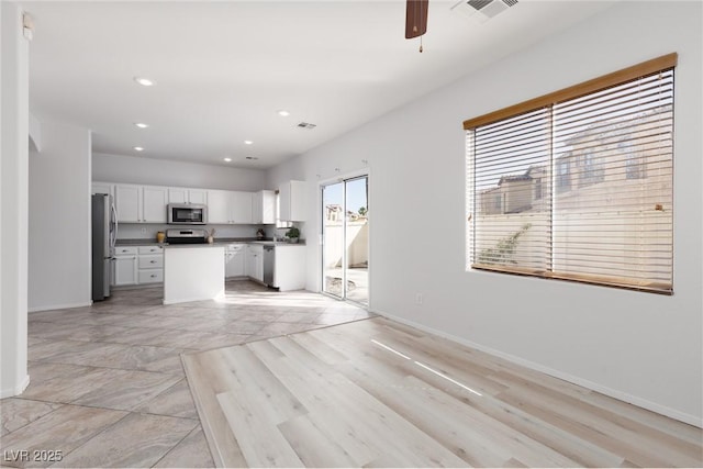 908 Shining Rose Pl, Henderson, NV 89052 - kitchen featuring appliances with stainless steel finishes, white cabinets, open floor plan, ceiling fan, and a kitchen island