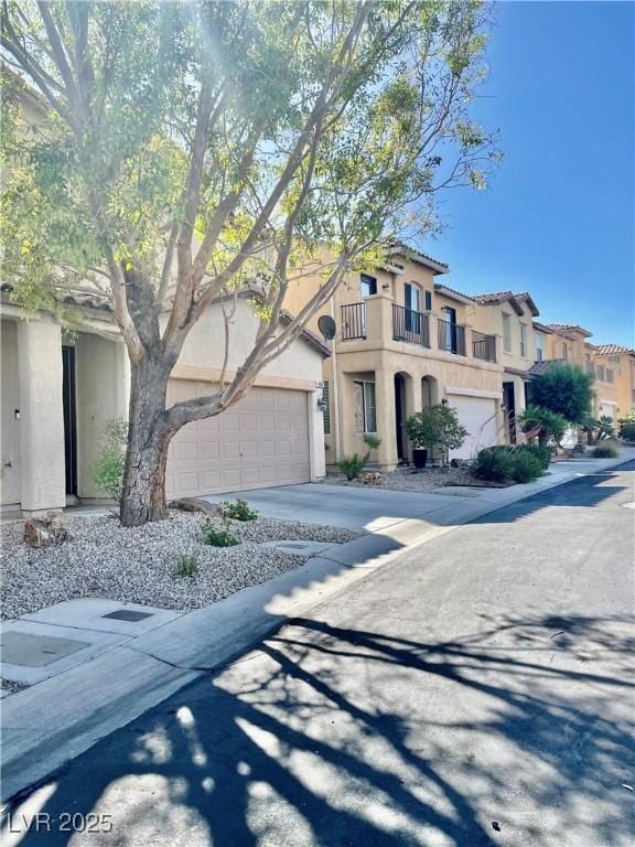 908 Shining Rose Pl, Henderson, NV 89052 - view of front of house featuring a balcony, stucco siding, concrete driveway, and a residential view