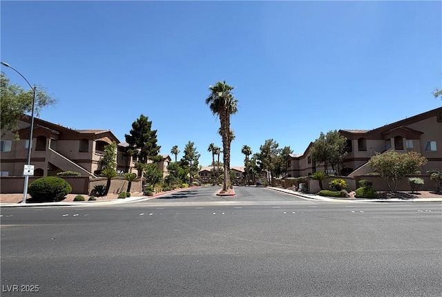 5751 E Hacienda Ave Unit 226, Las Vegas, NV 89122 - view of asphalt road with sidewalks, a residential view, curbs, and street lighting