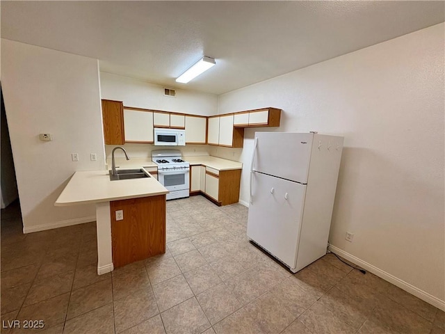 5751 E Hacienda Ave Unit 226, Las Vegas, NV 89122 - kitchen with white appliances, a peninsula, light countertops, and light tile patterned floors