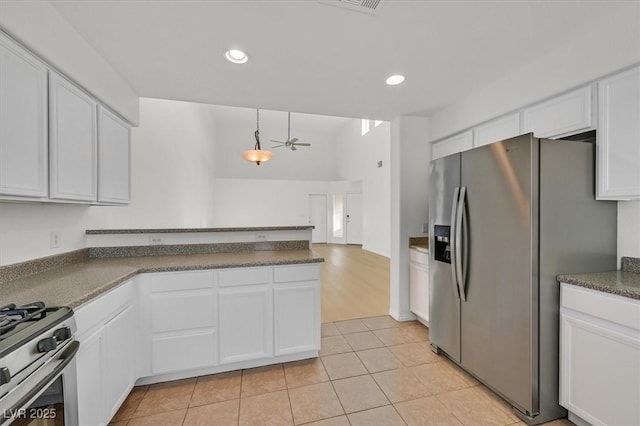 4708 Cohiba Way N, Las Vegas, NV 89031 - kitchen featuring appliances with stainless steel finishes, a peninsula, white cabinets, dark countertops, and light tile patterned flooring