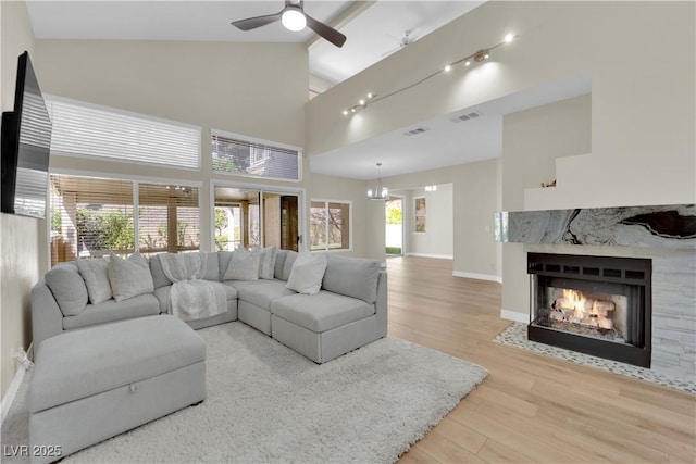 7837 Sea Rock Rd, Las Vegas, NV 89128 - living room featuring wood finished floors, ceiling fan, a premium fireplace, high vaulted ceiling, and beam ceiling
