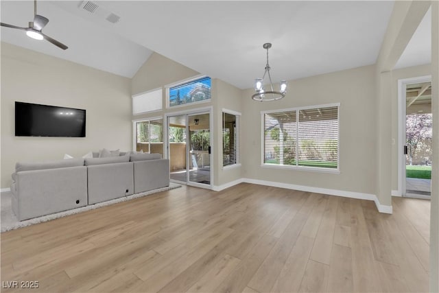 7837 Sea Rock Rd, Las Vegas, NV 89128 - unfurnished living room with a chandelier, healthy amount of natural light, light wood finished floors, and lofted ceiling