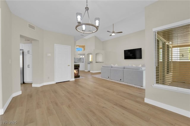 7837 Sea Rock Rd, Las Vegas, NV 89128 - unfurnished living room with a chandelier, a ceiling fan, light wood-type flooring, a multi sided fireplace, and high vaulted ceiling
