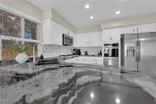 7837 Sea Rock Rd, Las Vegas, NV 89128 - kitchen featuring stainless steel appliances, light stone countertops, a warming drawer, backsplash, and white cabinetry