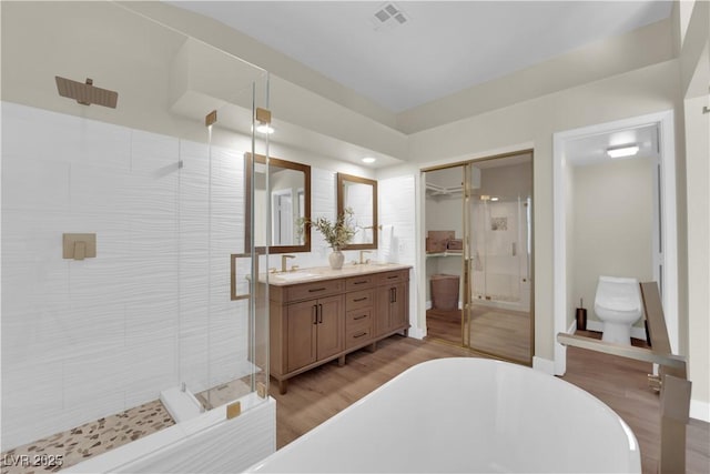 7837 Sea Rock Rd, Las Vegas, NV 89128 - full bathroom with a freestanding tub, a shower stall, double vanity, and wood finished floors
