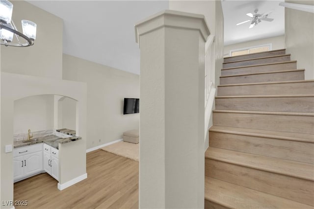 7837 Sea Rock Rd, Las Vegas, NV 89128 - stairway featuring wood finished floors, a chandelier, and ceiling fan