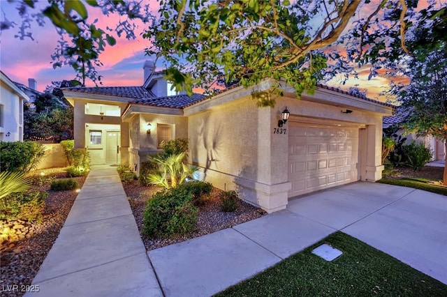 7837 Sea Rock Rd, Las Vegas, NV 89128 - mediterranean / spanish-style home featuring stucco siding, an attached garage, a tile roof, and concrete driveway